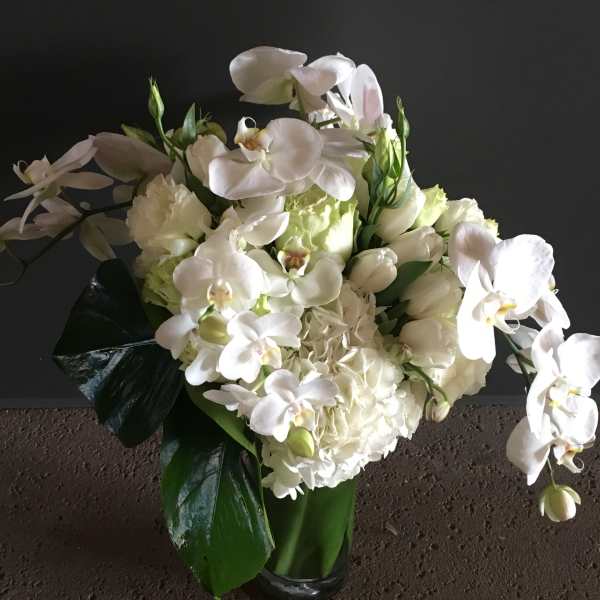 White orchid and hydrangea bouquet in a glass vase
