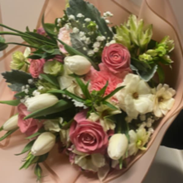 Bouquet of pink and white flowers wrapped in blush paper