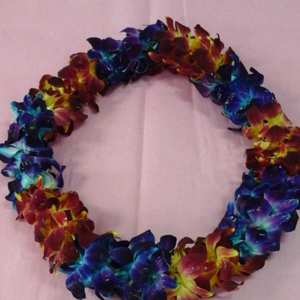 Colorful flower lei made of clustered blossoms on pink paper