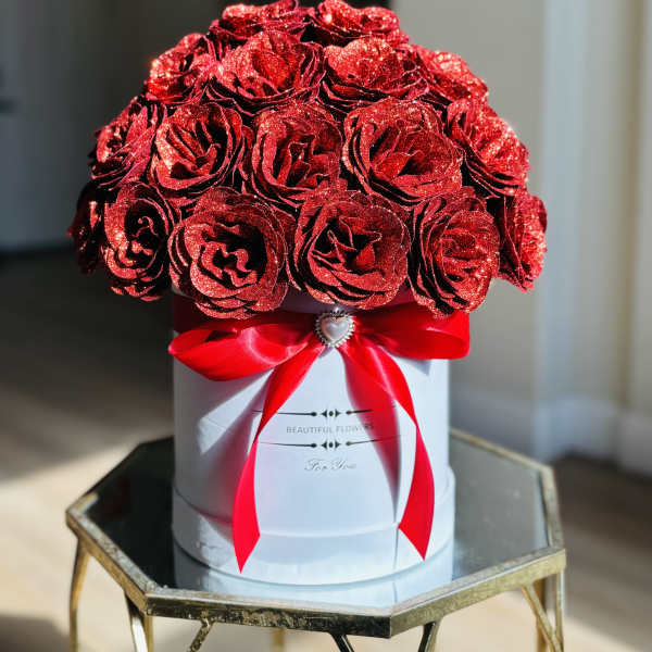Red glitter roses in a white hat box with a red ribbon
