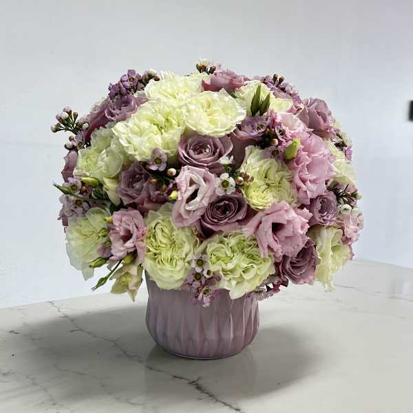 Pink and white bouquet in a lavender vase