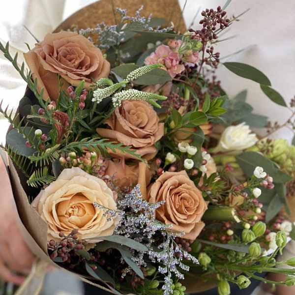 Bouquet of peach roses with small pink and white filler flowers