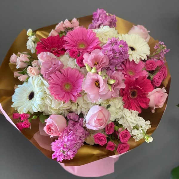 Pink and white mixed bouquet with gerbera daisies and roses wrapped in gold paper