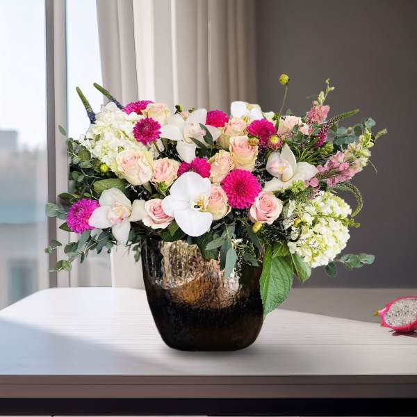 Mixed pink and white flowers arranged in a dark vase