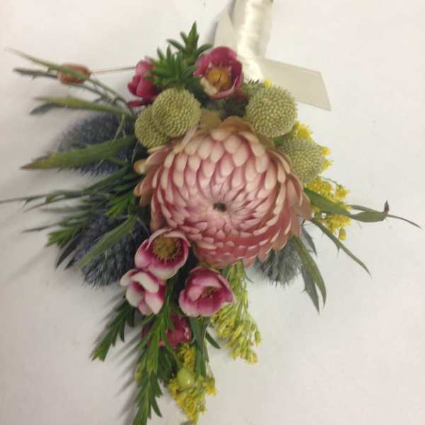 Pink and green floral corsage with a large central bloom