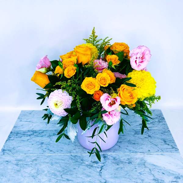 Bouquet of yellow and pink roses in a white vase