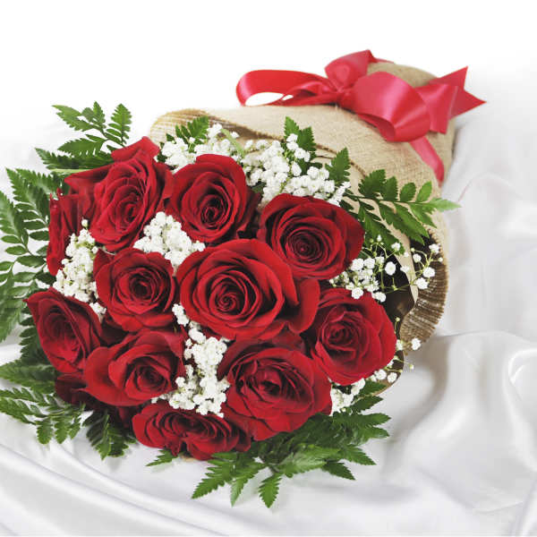 Bouquet of red roses with white baby's breath wrapped in burlap and tied with a red ribbon