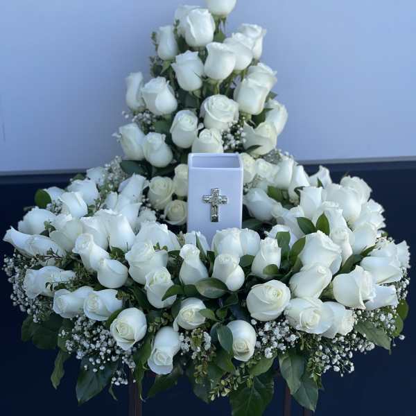 Large white rose funeral spray with a cross ornament