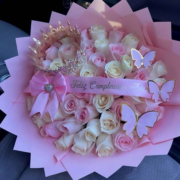 Pink and white rose bouquet with butterfly decorations and a ribbon