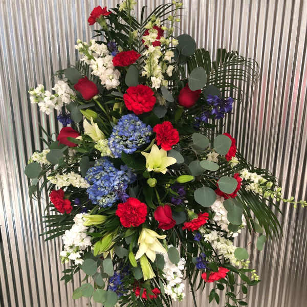 Standing floral spray with red, white, blue, and yellow flowers
