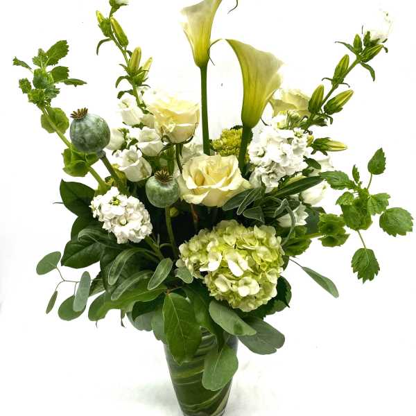 White and pale green floral arrangement in a glass vase