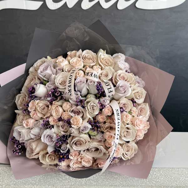 Large bouquet of pale pink and cream roses with purple accents