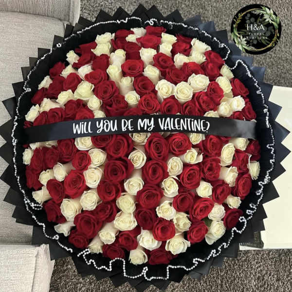 Round bouquet of red and white roses with a Valentine ribbon