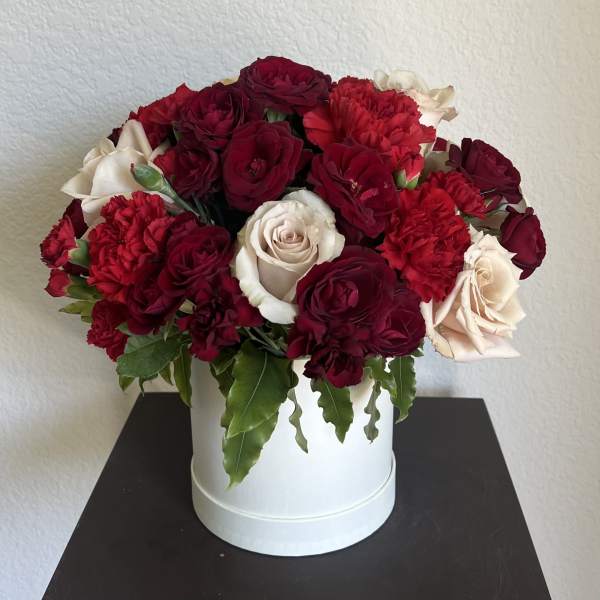 Red and white roses with red carnations in a white box
