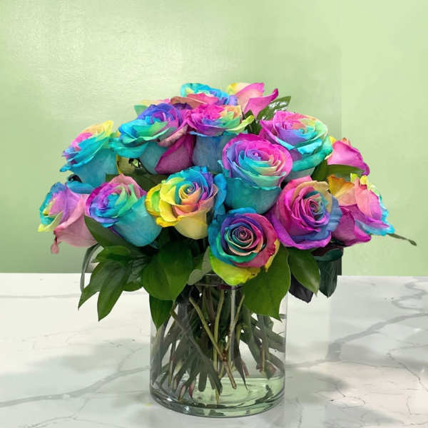Rainbow roses arranged in a clear glass vase