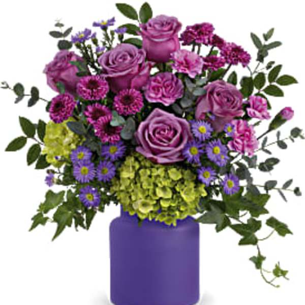 Purple and green mixed bouquet in a purple vase