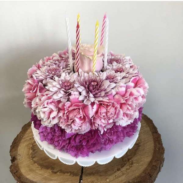 Pink floral cake with striped candles on top