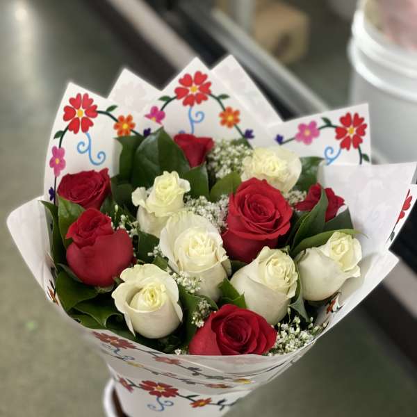Bouquet of red and white roses wrapped in floral paper