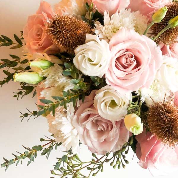 Bouquet of pale pink and white roses with white blooms and bronze accents