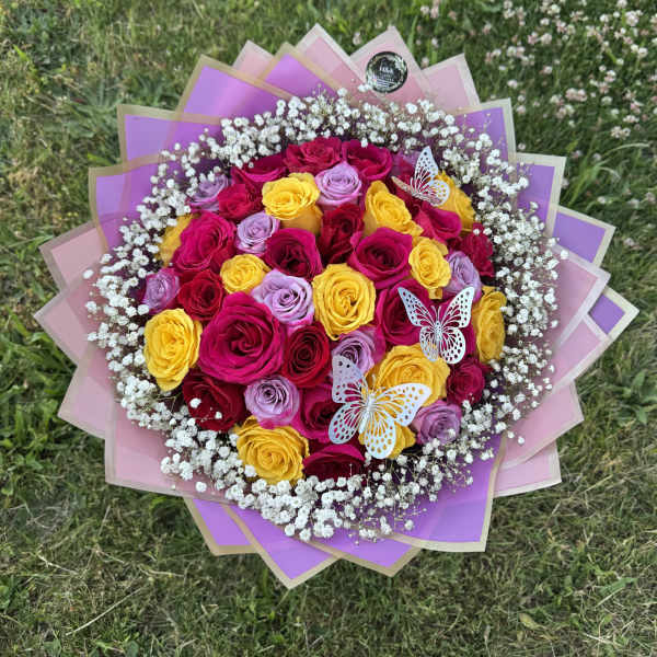 Bouquet of pink, yellow, and lavender roses with white baby's breath