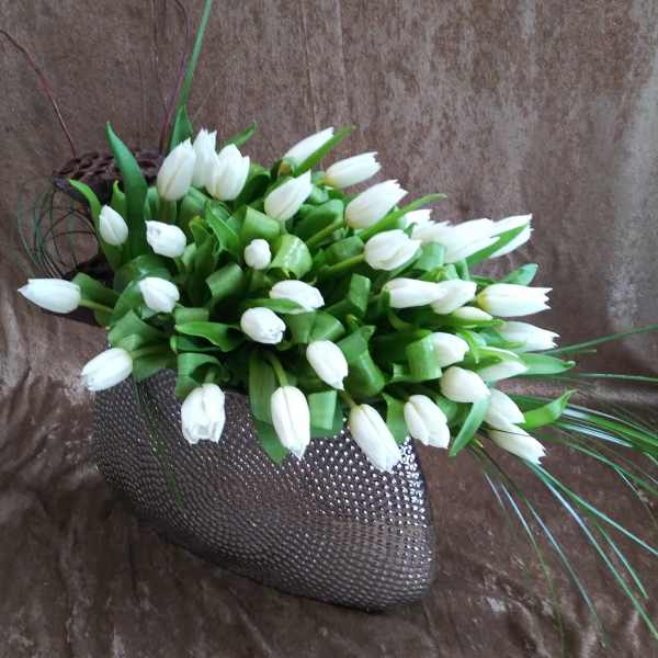 White tulips arranged in a textured dark vase