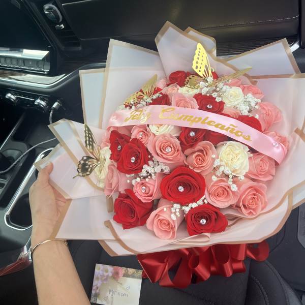 Bouquet of red and pink roses with a pink birthday ribbon
