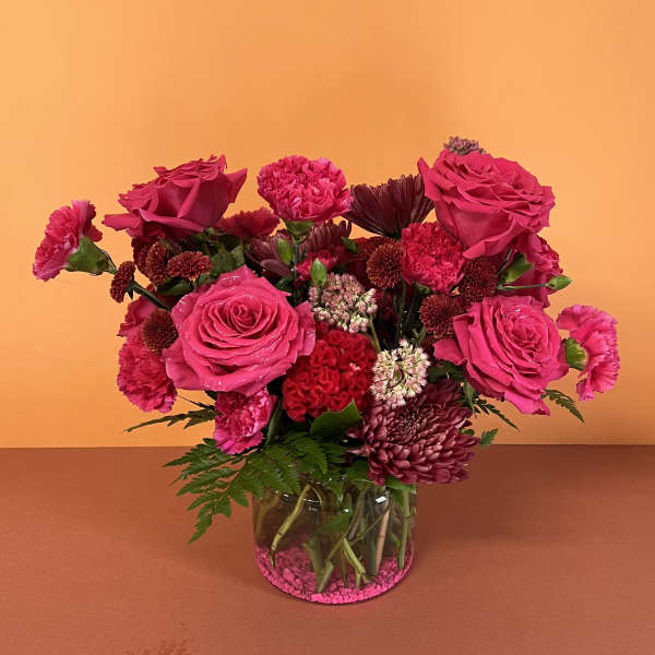 Pink roses and carnations arranged in a glass vase