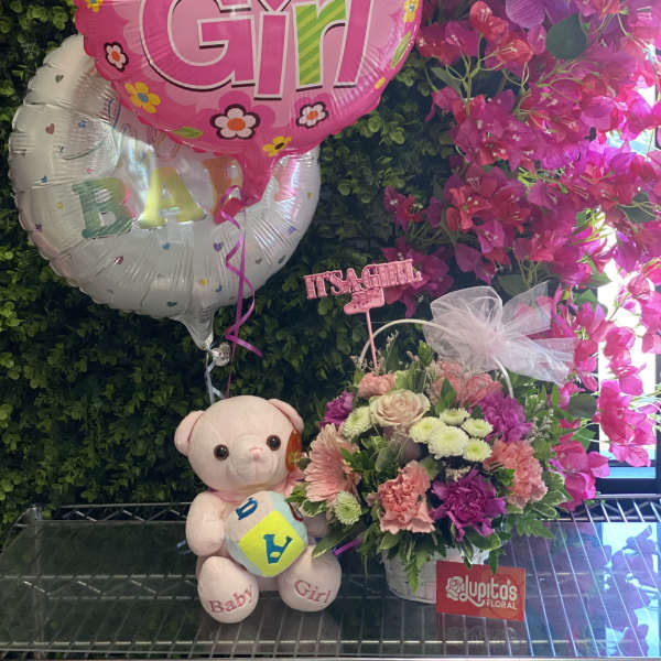 Pink baby girl balloon with flowers, teddy bear, and floral arrangement