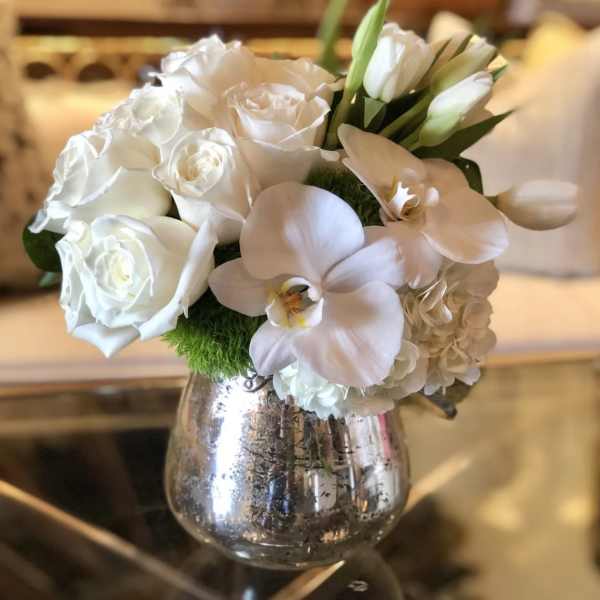 White roses and orchids in a silver vase