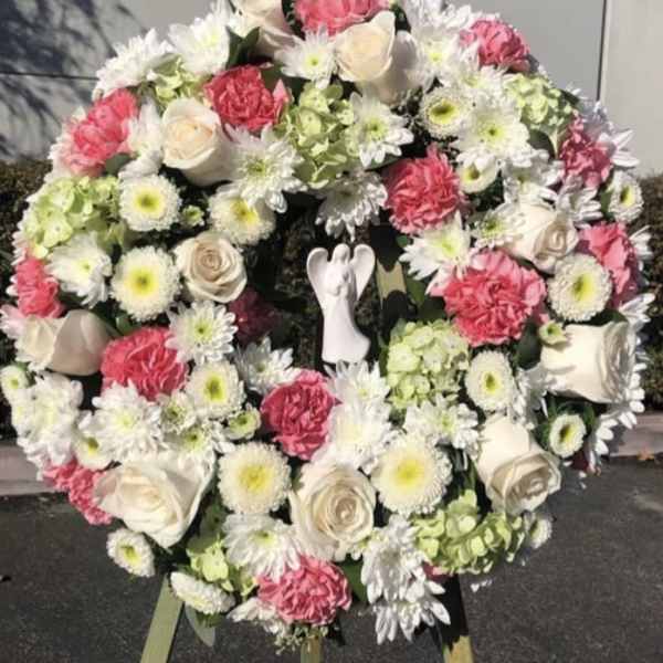 Large floral wreath with pink and white flowers on an easel