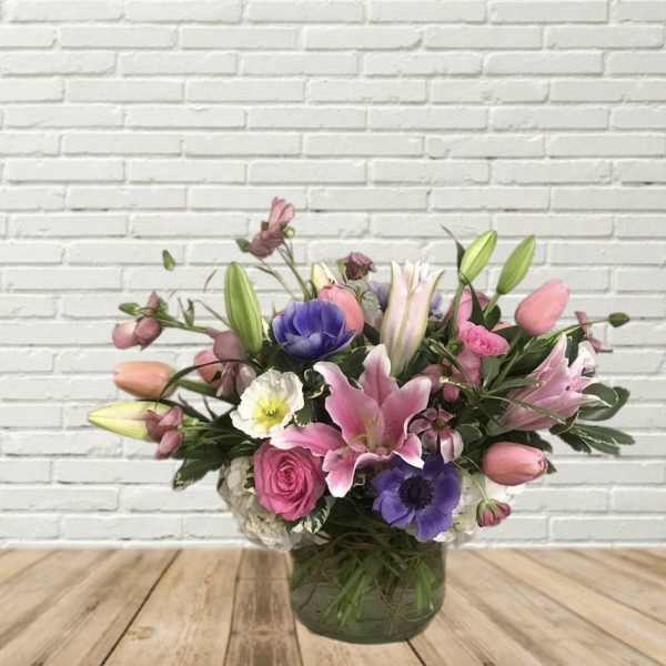 Mixed pink and purple flower arrangement in a glass vase
