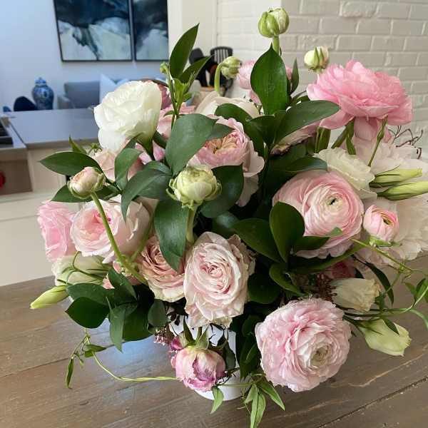 Pink and white ranunculus bouquet in a low white vase