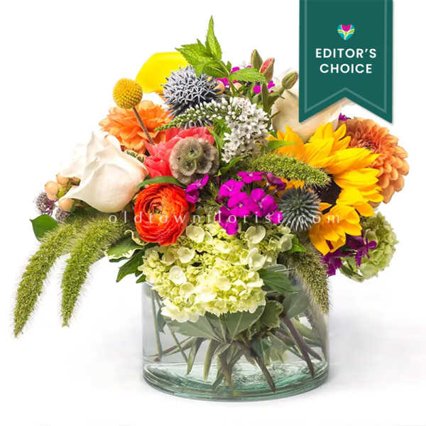 Colorful mixed bouquet in a clear glass vase with sunflowers and hydrangeas