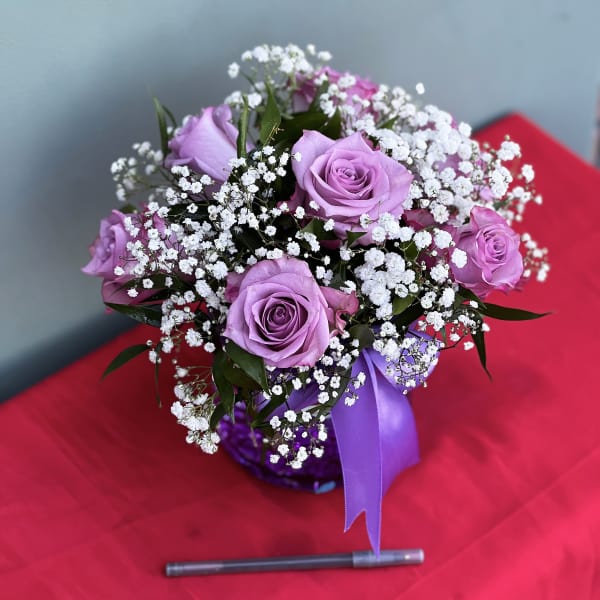 Lavender rose bouquet with white baby's breath and a purple ribbon