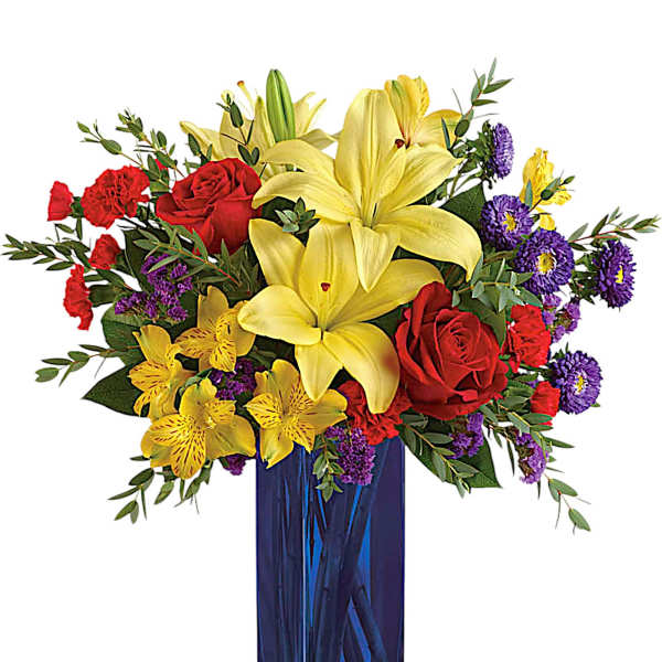 Bouquet of yellow lilies, red roses, and purple flowers in a blue vase