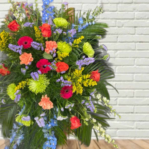 Large mixed floral spray with roses, gerbera daisies, and blue delphinium