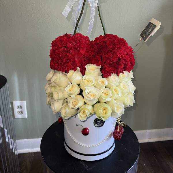 Red carnations and white roses in a white hatbox with pearl ribbon