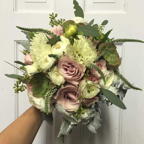 Handheld bouquet of blush and white flowers with greenery