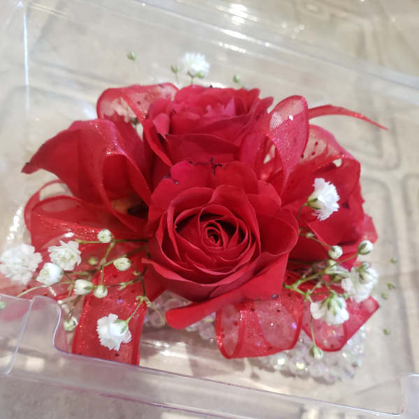 Red rose arrangement with white baby's breath in a clear box