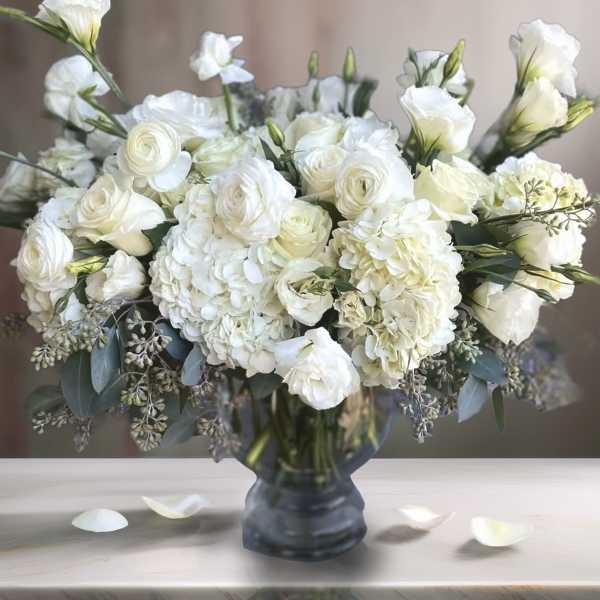 White floral arrangement in a dark glass vase