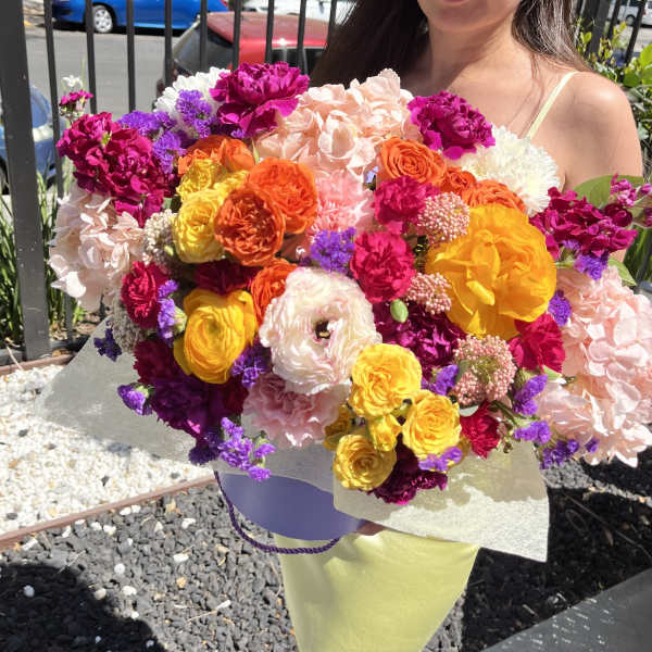 Large mixed bouquet of bright pink, yellow, orange, white, and purple flowers