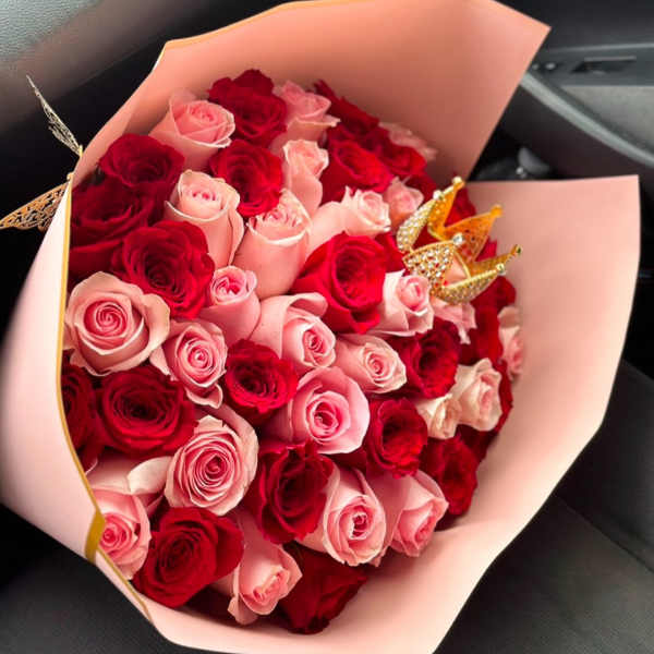 Bouquet of red and pink roses wrapped in pale pink paper