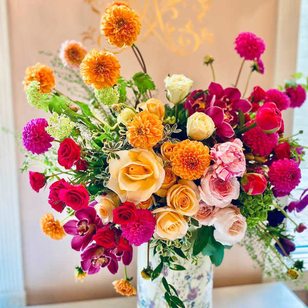 Colorful bouquet of roses, dahlias, and orchids in a floral vase