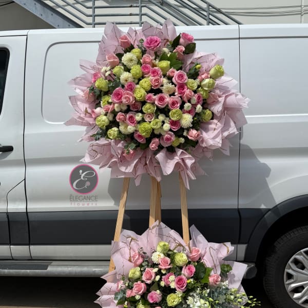 Two large pink and green floral stands with roses and mums