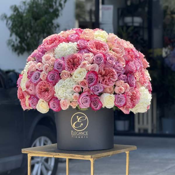 Large dome bouquet of pink, white, and lavender roses in a black hat box