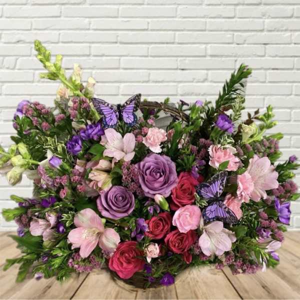 Mixed bouquet of pink and purple flowers with butterfly accents