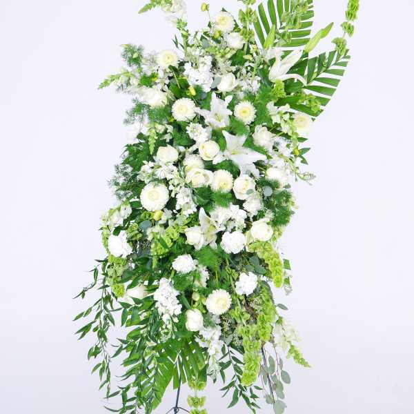 Tall white floral standing spray with lilies and roses