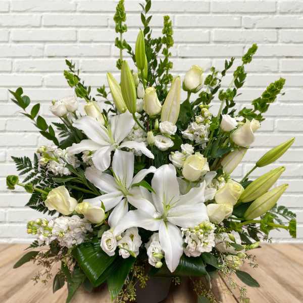 White lilies and cream roses in a low arrangement