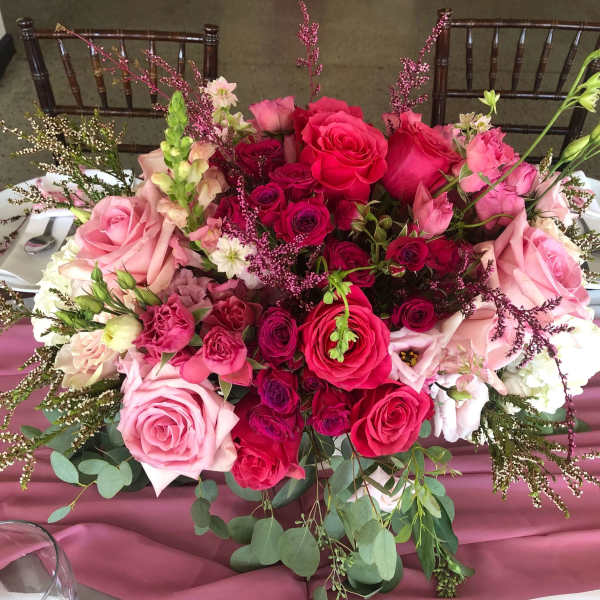 Large pink and red rose centerpiece on a table