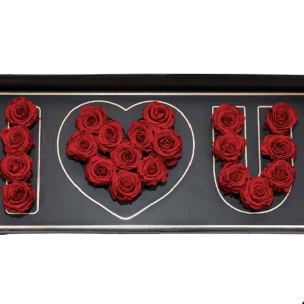 Red roses arranged to spell I heart U in a black box